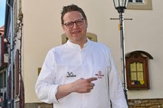 Stolz präsentiert Markus Pape den Michelin-Stern auf seiner neuen Kochjacke, die ihm bei der Michelin Guide Ceremony geschenkt wurde.